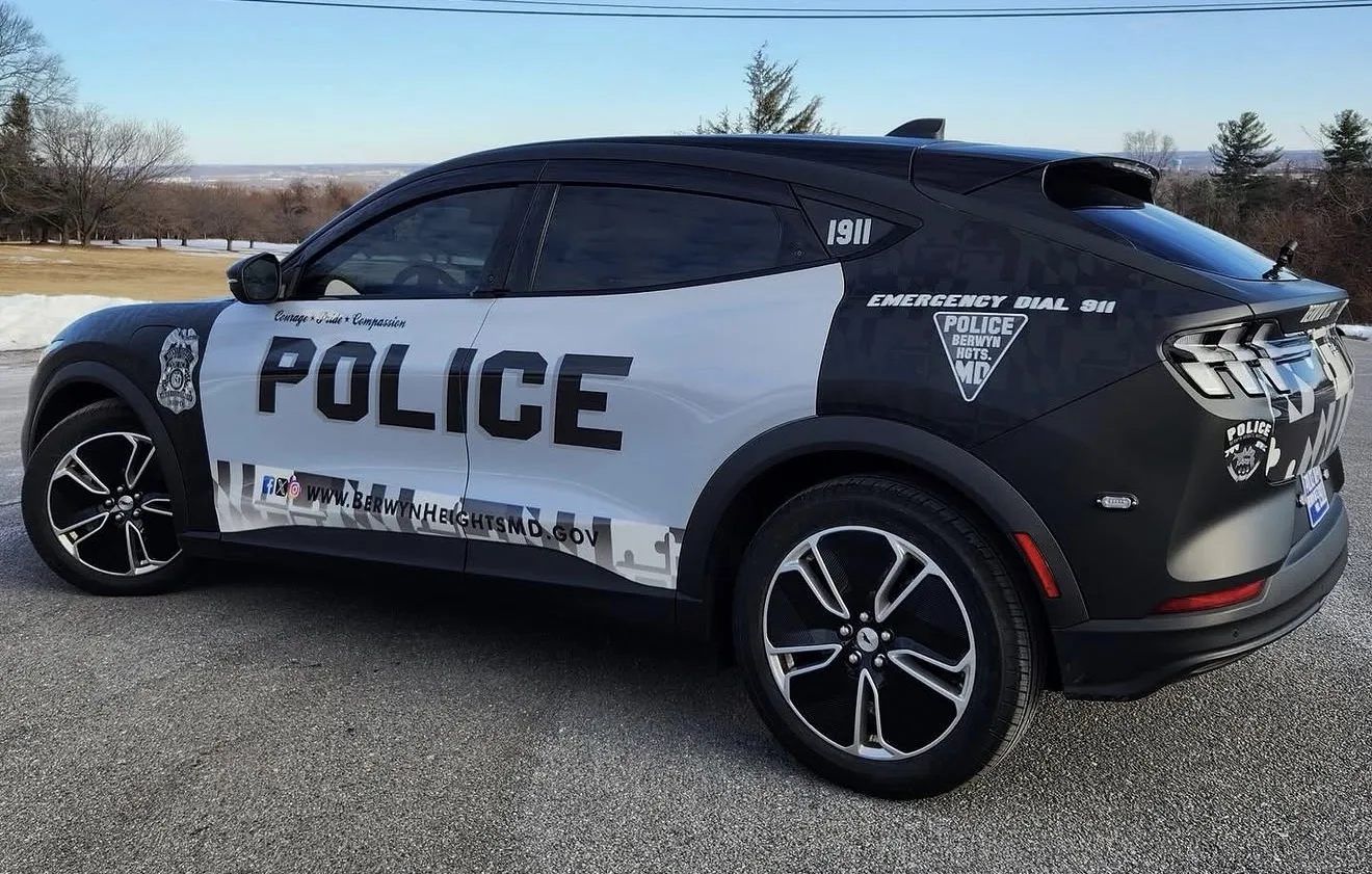 Berwyn Heights, MD police Mustang Mach-E with a black and white POLICE wrap and Maryland flag pattern, side view