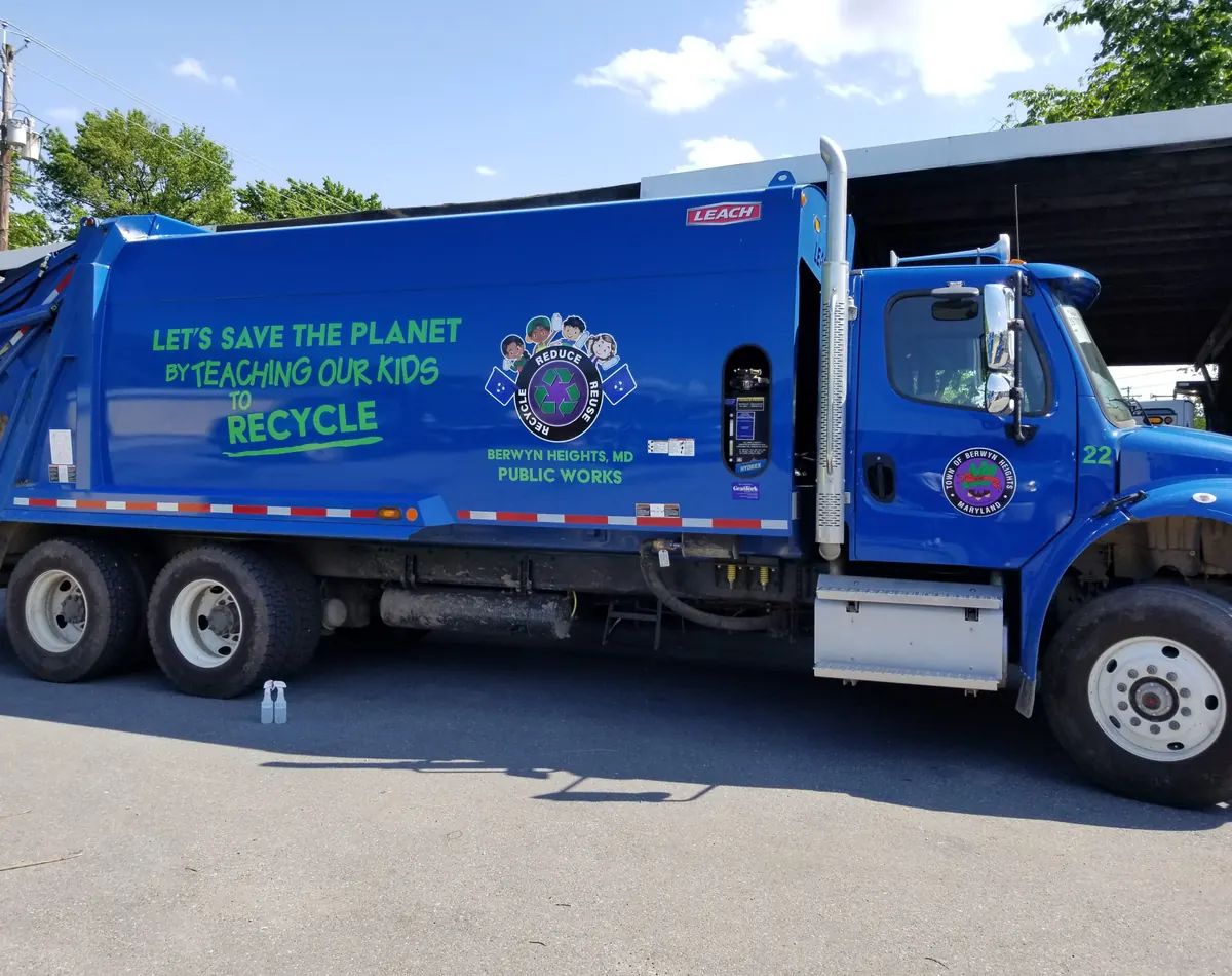 Blue public works truck with green lettering and a town seal
